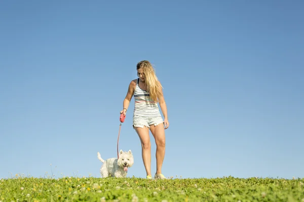 Portrait of beautiful girl keeping pretty white West Highland dog outdoor — Stock Photo, Image