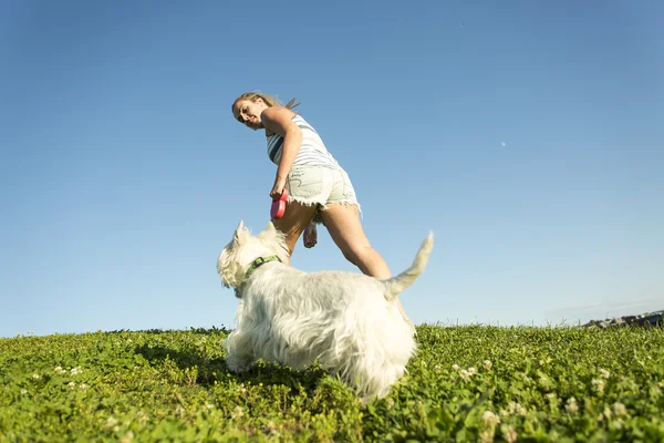 Porträtt av vacker flicka att hålla ganska vita West Highland hund utomhus — Stockfoto