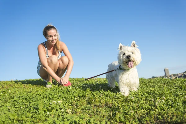 Retrato de hermosa chica mantener bastante blanco West Highland perro al aire libre —  Fotos de Stock