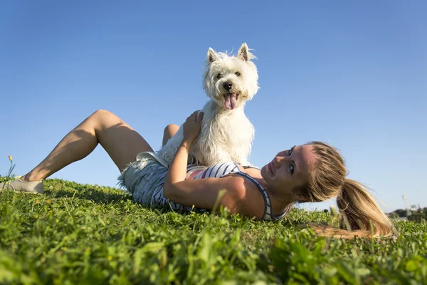Retrato de hermosa chica mantener bastante blanco West Highland perro al aire libre —  Fotos de Stock