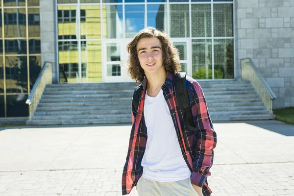 Jonge knappe mannelijke student aan het college, buitenshuis. — Stockfoto