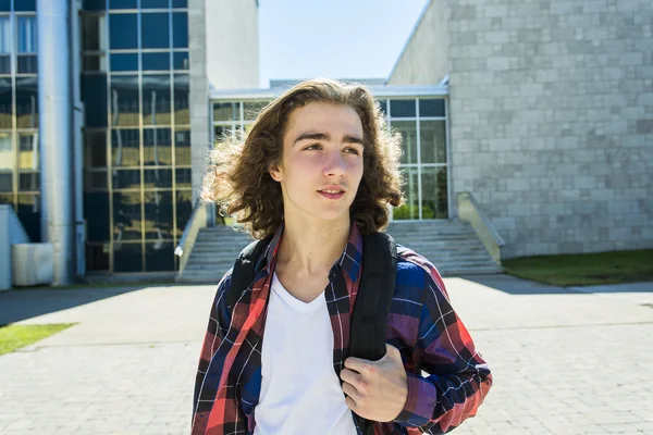 Jonge knappe mannelijke student aan het college, buitenshuis. — Stockfoto