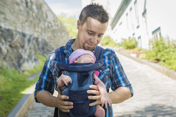 Father holding baby in a front bag — Stock Photo, Image