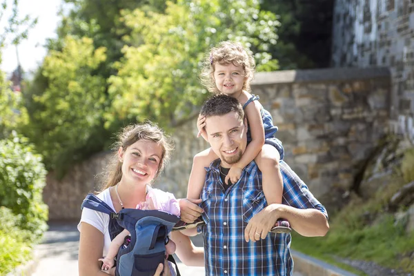 Счастливая семья гуляет по парку в день отпуска — стоковое фото