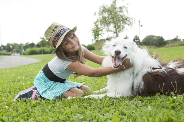 Porträtt av flicka att hålla ganska hund utomhus — Stockfoto
