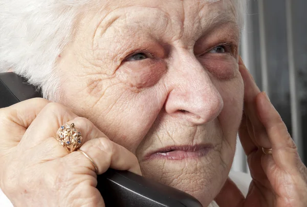 Pensive elderly woman calling on the phone — Stock Photo, Image