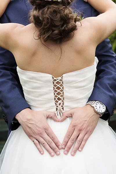 Heart shape hands of groom around bride at wedding — Stock Photo, Image