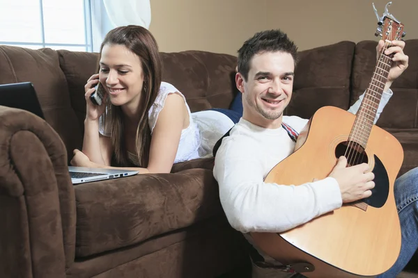 Man serenading his girlfriend with guitar at home — Stock Photo, Image