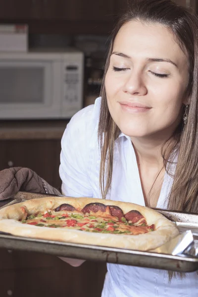 Une femme avec une délicieuse pizza sur la cuisine — Photo