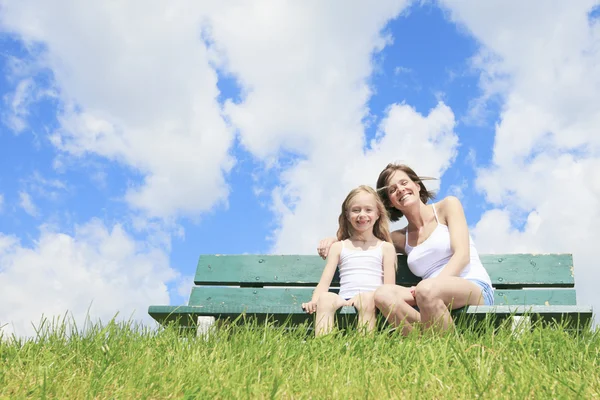 Woman with his child sitting on the bench — Stock Photo, Image