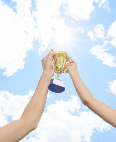 Happy mother and daughter holding a trophy high up — Stock Photo, Image