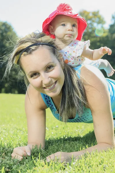 En mor træning med baby på en sommerdag - Stock-foto