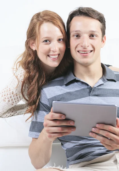 Beau couple sur canapé avec tablette numérique — Photo