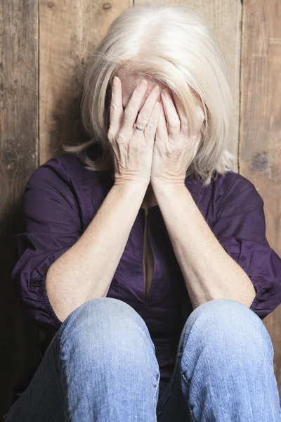 Depress senior person with wood background — Stock Photo, Image