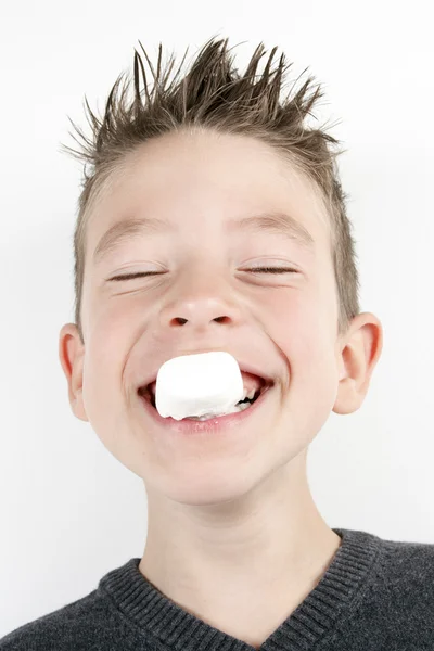 Portrett av en søt, lykkelig gutt med en marshmallow – stockfoto