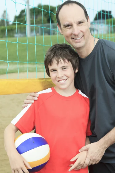 Retrato de familia feliz sosteniendo voleibol afuera — Foto de Stock