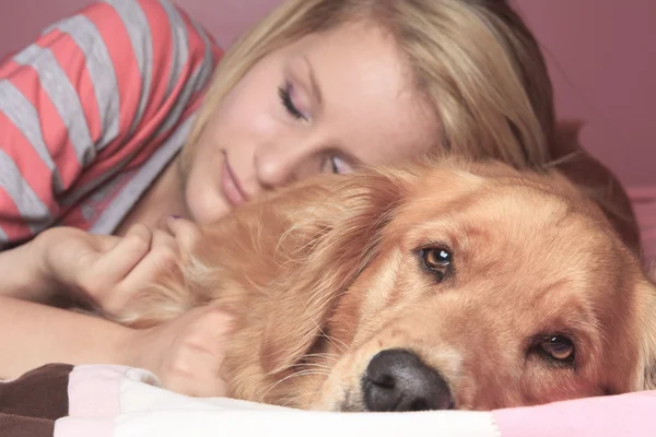 Девушка и ее собака спят вместе в спальне — стоковое фото