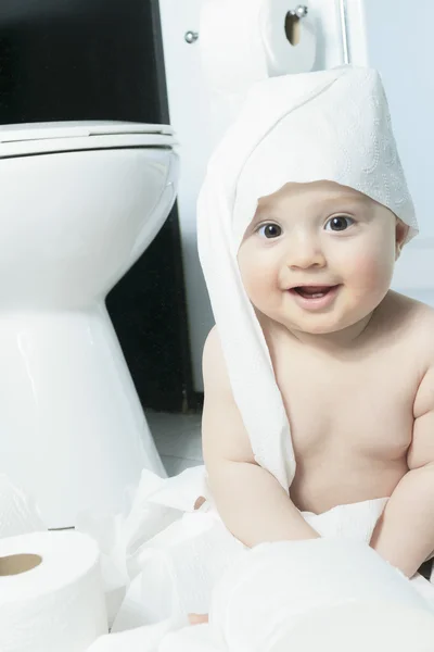 Toddler ripping up toilet paper in bathroom — Stock Photo, Image