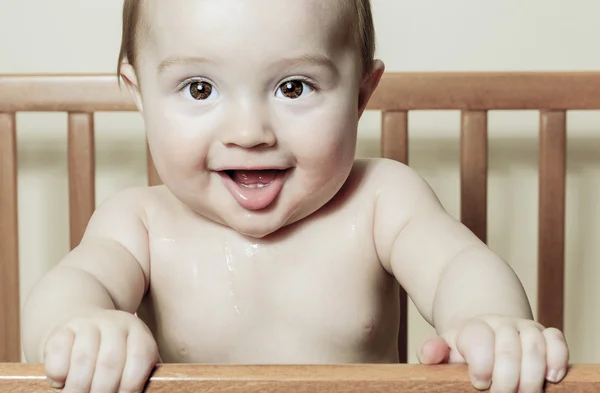 Funny little baby with beautiful standing in a round white crib — Stock Photo, Image