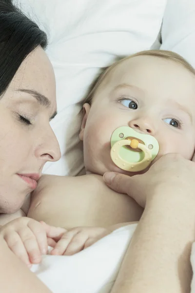 Giovane madre e il suo bambino, dormire a letto — Foto Stock