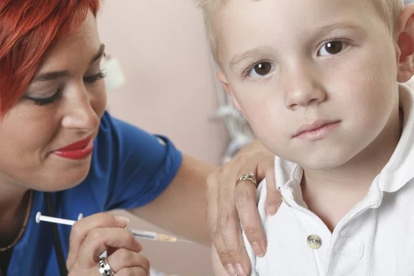 Kleine jongen verpleegster geeft hem een schot. — Stockfoto