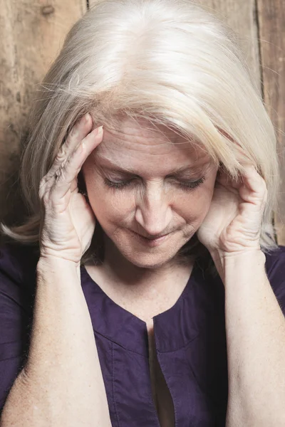 Depress senior person with wood background — Stock Photo, Image