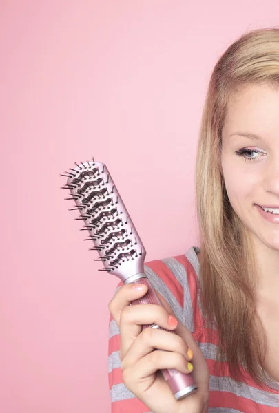 Adolescente que escovar o cabelo em seu quarto — Fotografia de Stock