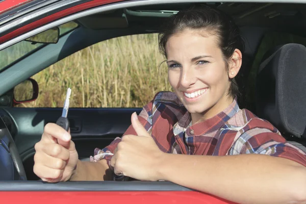 Una hermosa mujer sentada en su coche nuevo, sosteniendo las llaves . — Foto de Stock