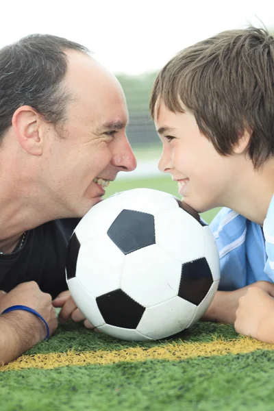 En ung fotballspiller med far – stockfoto