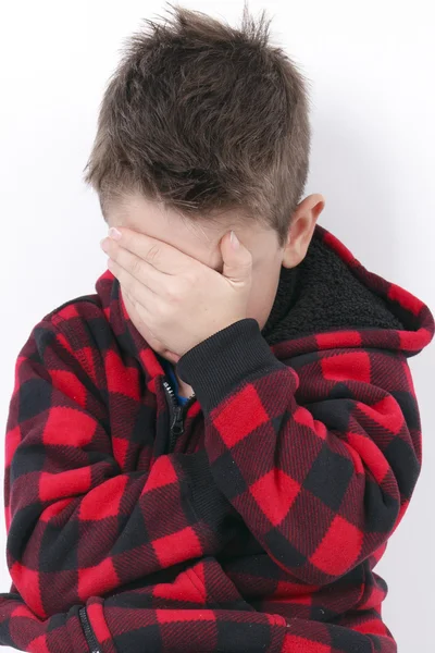 Triste jovem rapaz sentar no fundo branco — Fotografia de Stock