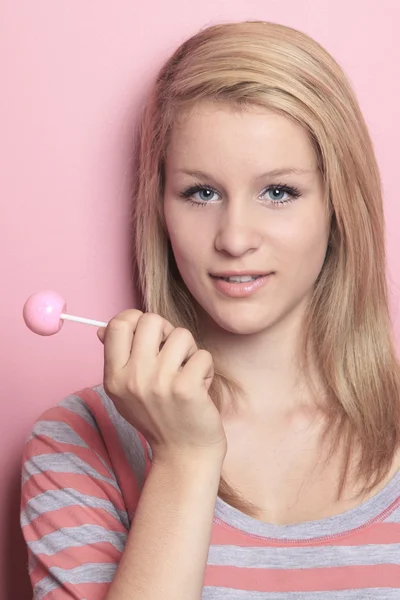 Chica con piruleta en su dormitorio — Foto de Stock