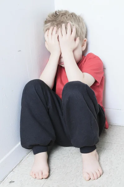 Trascurato bambino solitario appoggiato al muro — Foto Stock