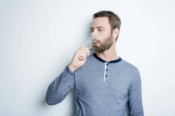 Portrait of a young man smoking electric cigarette — Stock Photo, Image