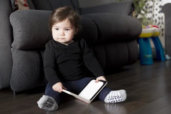 Petite fille avec livre sur le salon — Photo