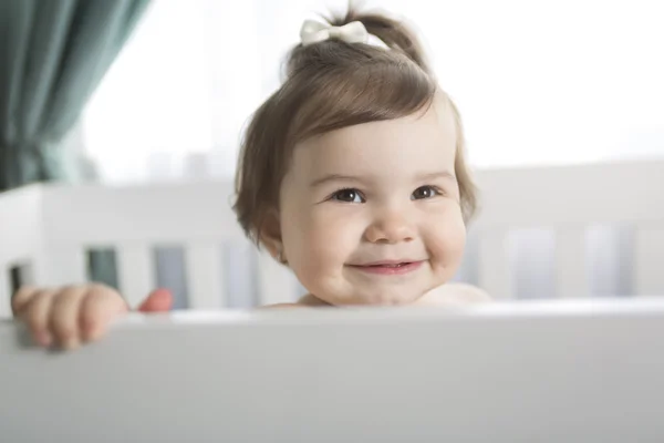 Säugling ruht und spielt in seinem kleinen Babybett — Stockfoto