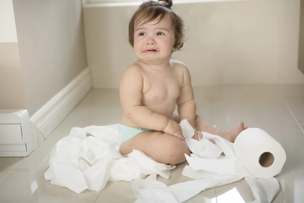 Toddler ripping up toilet paper in bathroom — Stock Photo, Image