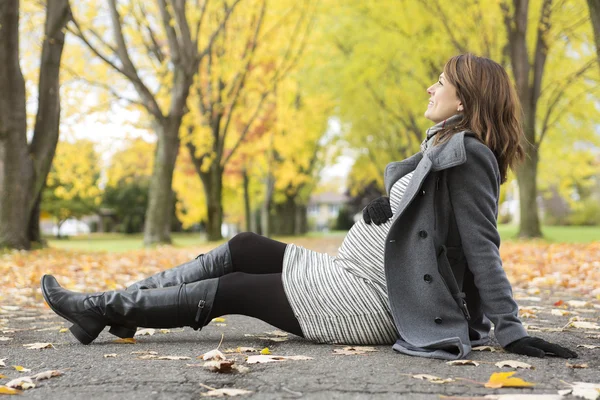 Красивая беременная женщина в осеннем парке — стоковое фото