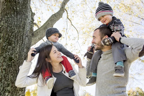 Família feliz se divertindo no parque de outono — Fotografia de Stock