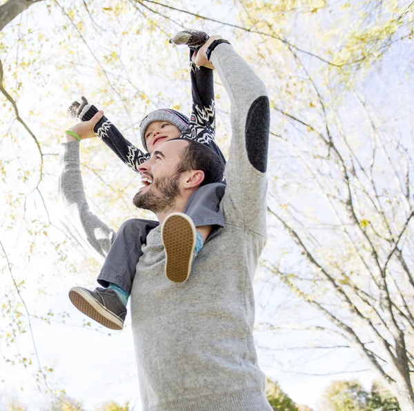 秋の公園で彼の肩の上の幸せな父を与える息子おんぶの肖像画. — ストック写真