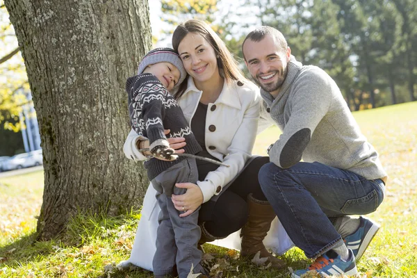 Família feliz se divertindo no parque de outono — Fotografia de Stock