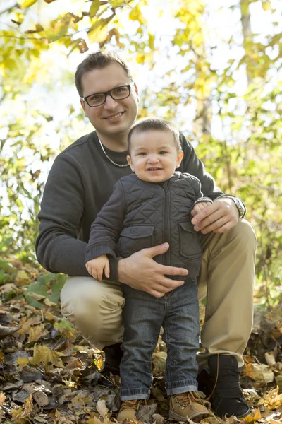 Father and son playing at park in autumn — Stock Photo, Image