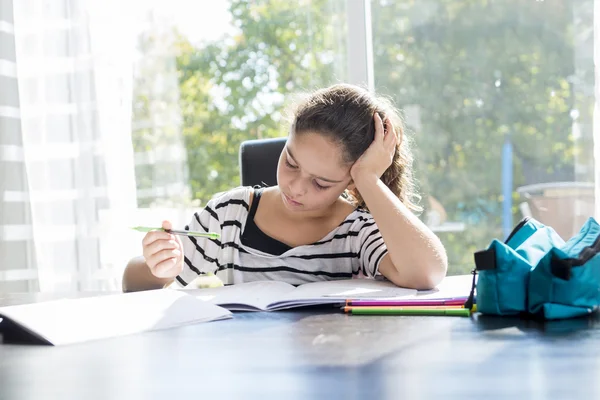 Scolaretta che studia con libri sul tavolo della cucina — Foto Stock