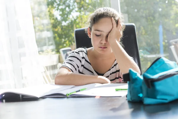 Schoolmeisje studeren met boeken op de keukentafel — Stockfoto