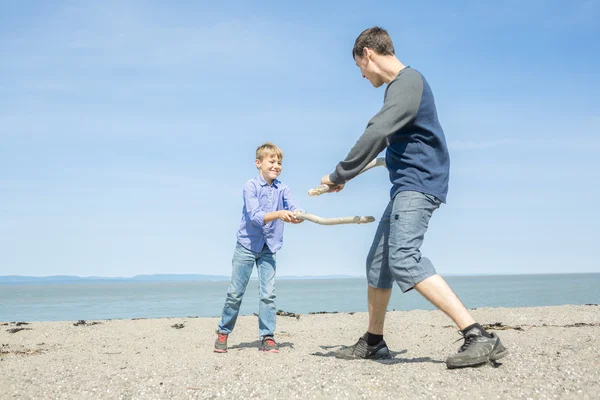 Far spela son sidan av stranden — Stockfoto