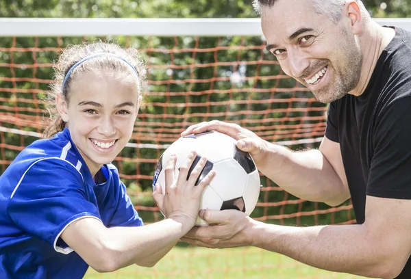 十几岁的女孩与他的父亲在美丽的一天踢足球 — 图库照片