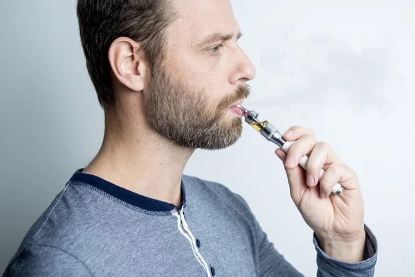 Portrait of a young man smoking electric cigarette — Stock Photo, Image