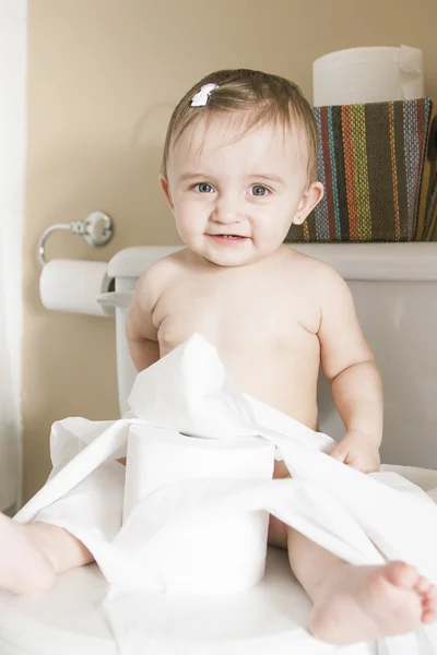 Toddler ripping up toilet paper in bathroom — Stock Photo, Image