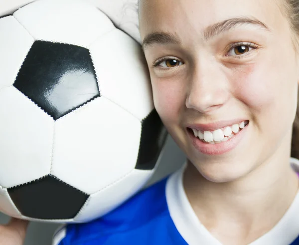 Κορίτσι στο άθλημα φθορά με το ποδόσφαιρο που απομονώνονται σε λευκό φόντο — Φωτογραφία Αρχείου