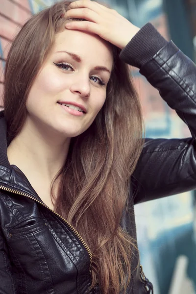 Young and beautiful girl posing against graffiti wall — Stock Photo, Image