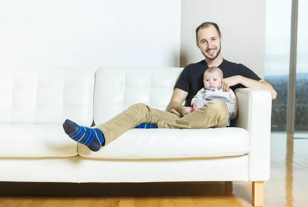Πατέρα με το μωρό στον καναπέ — Φωτογραφία Αρχείου